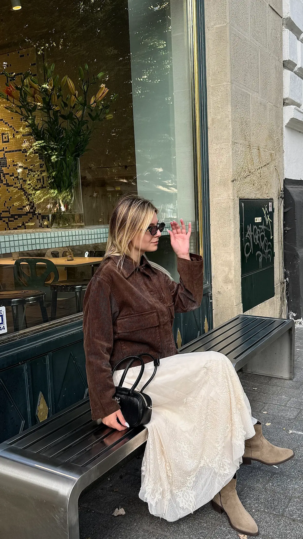 A woman in a stylish outfit sitting on a bench